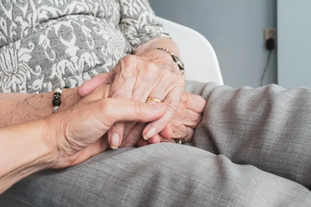 une main qui tient la main d'une personne âgée